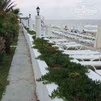 Green Paradise Beach Hotel 4* Пляж ранним утром. Зонтики, которые &#34;не стоят&#34;, лежат рядом с лежаками. - Фото отеля