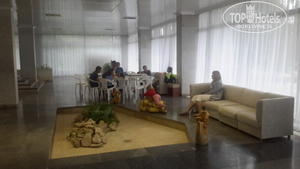 Таврия Вестибюль 4-го корпуса, там же ресепшн. На фото - работа аниматоров. В дождливый день столы перенесли с улицы в здание. - Фото отеля