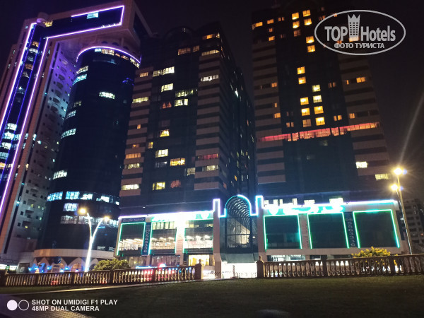 Golden Tulip Sharjah 4* здание справа - это отель (красным светится ресторан) - Фото отеля